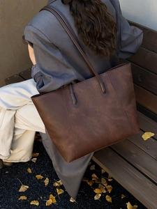 Minimalist large brown leather tote bag with vintage texture shown in an autumn setting