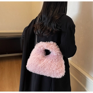 Makroansicht der rosa Kunstfell-Handtasche mit Plüschtextur und Metallkettenriemen