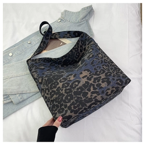 Detail of large leopard print tote bag in blue and brown on casual white bedding