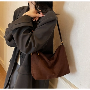 Detail of hobo bag in dark brown suede showing fine texture and leather strap