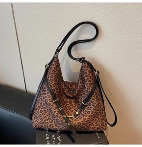 Detail of leopard print hobo bag showing texture, black straps and gold metal hardware