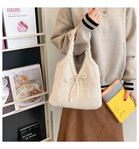 Detail of cream knit tote bag with bow accent shown in a warm autumn lifestyle setting