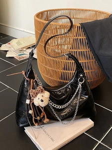 Retro black patent leather shoulder bag with silver chains and a plush bear pendant