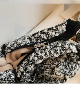 Detail view of tweed shoulder bag with smooth silver zipper and metal chain link