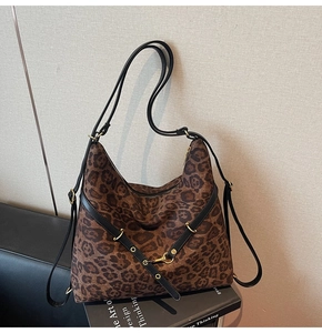 Detail of leopard print hobo bag with adjustable black strap and golden metal buckle decoration