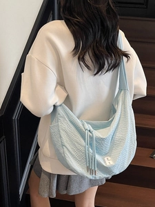 Light blue large hobo bag with waffle texture shown on model in a staircase setting