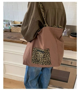 Close-up of leopard print shoulder strap on a brown canvas tote bag in a kitchen