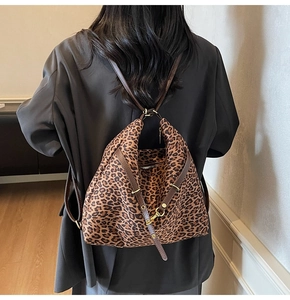 Detailed back view of a leopard print bucket bag with adjustable brown shoulder straps