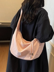 Large light pink canvas shoulder bag with woven texture worn by model for daily commute
