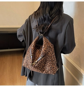 Detail view of large leopard print bucket bag featuring retro matte finish and gold buckles