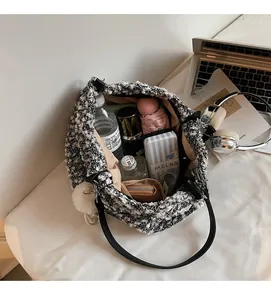 Detail showing spacious interior of black and white tweed tote bag with daily essentials