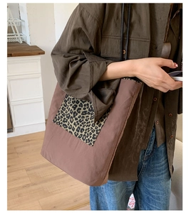 Detail shot of a brown tote bag featuring leopard print pocket and sturdy stitch work