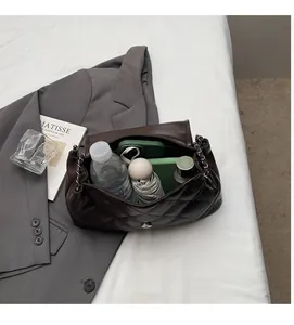 Vue détaillée du sac cabas matelassé marron foncé montrant l'espace intérieur et la chaîne