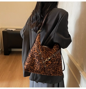 Detailed view of leopard print tote bag with brown leather straps and gold buckle
