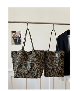 Detailed close-up of leopard print canvas tote bags with various sizes and slogans