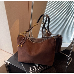 Detail of dark brown suede shoulder bag featuring a vintage chain strap and gold hardware