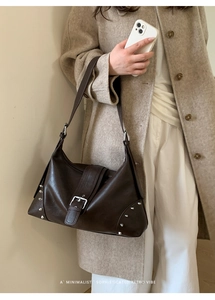 Detail of retro dark brown PU leather tote with silver buckle and rivet accents