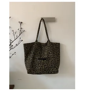 Close-up of leopard print canvas tote bag featuring a front pocket and soft texture