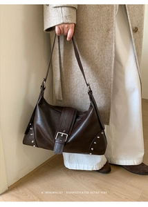 Macro shot of dark brown leather texture with silver rivet details and strap on tote bag