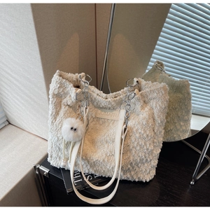 Detail of white fuzzy tote bag featuring silver chain strap and signature eye bag charm