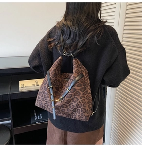Detail showing vintage leopard print backpack with matte texture and gold metal buckles