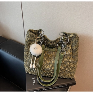 Detail of green fuzzy lamb wool tote bag with metal chain handle and plush charm