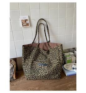 Detailed close-up of leopard print tote bag with Own The Moment black rectangular label