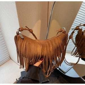 Detail of bohemian crescent bag with caramel suede fringe and knotted handle design