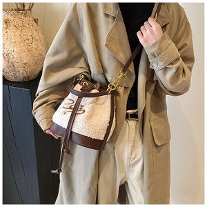 Detail of plush bucket bag with brown leather drawstring and golden hardware accents