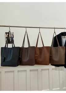 Minimalist pebbled leather tote bags in four colors hanging on a metal rack