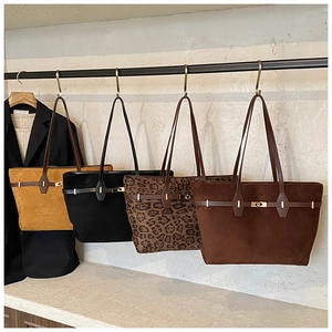 Detail showing four vintage faux suede tote bags in leopard print and solid colors with metal buckles