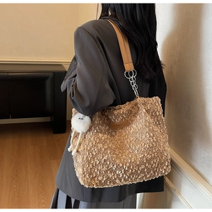 Detail of brown faux shearling tote bag with leather strap and silver chain link