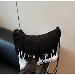 Detail shot of black suede tassel bag showing bohemian fringe and metallic zipper closure