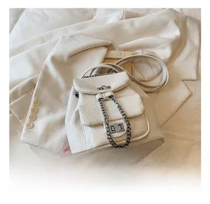 Detailed shot of white lychee texture leather backpack with silver chain and metal lock