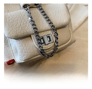 Detail of off-white textured leather backpack with polished silver chain and metal clasp