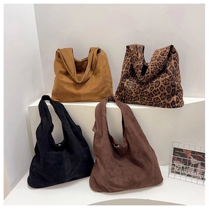 Collection of large leopard print and solid suede tote bags on geometric display