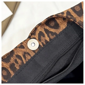 Macro shot of magnetic closure and internal zipper compartment of leopard tote bag