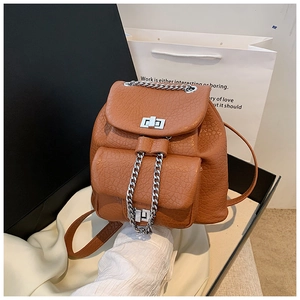 Close-up of brown litchi pattern leather backpack with chain detail and metal clasp
