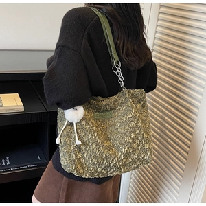 Detail of olive green sherpa tote bag with leather logo patch and cute plush charm