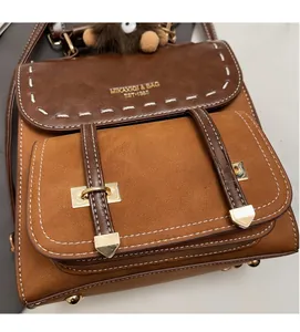 Dettaglio dello zaino patchwork vintage in pelle scamosciata marrone con ciondolo