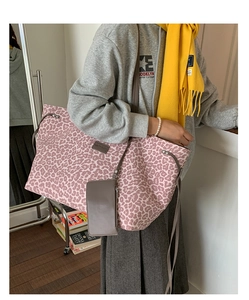 Détail du grand sac cabas en toile léopard rose avec bandoulière et pochette en cuir gris