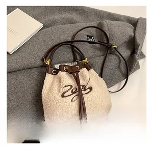 Detailed view of plush lamb wool bucket bag with drawstring closure and 2023 embroidery