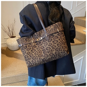 Detail of leopard print tote bag with dark brown strap and buckle closure decoration
