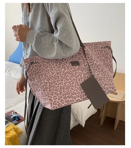 Détail du sac cabas léopard rose avec mini porte-monnaie et cordon de serrage dans une chambre