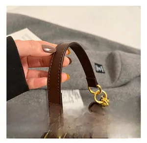 Close-up of brown leather handle with golden rings on a plush faux fur bucket bag