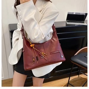 Détail du sac cabas bordeaux avec franges ethniques et tirette papillon en métal