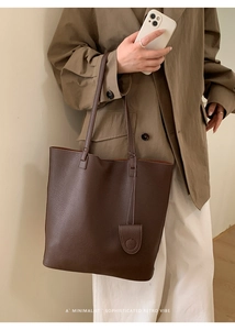 Detail of dark brown tote bag with lychee grain texture and minimalist retro aesthetic