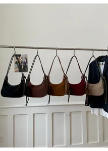 Hobo shoulder bags in five colors with drawstring details hung on a minimalist metal rack