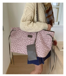 Gros plan sur un grand sac cabas imprimé léopard avec sa petite pochette assortie