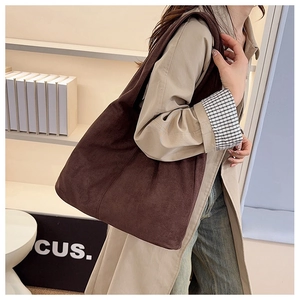 Close-up of deep brown suede tote bag featuring smooth texture and long shoulder straps